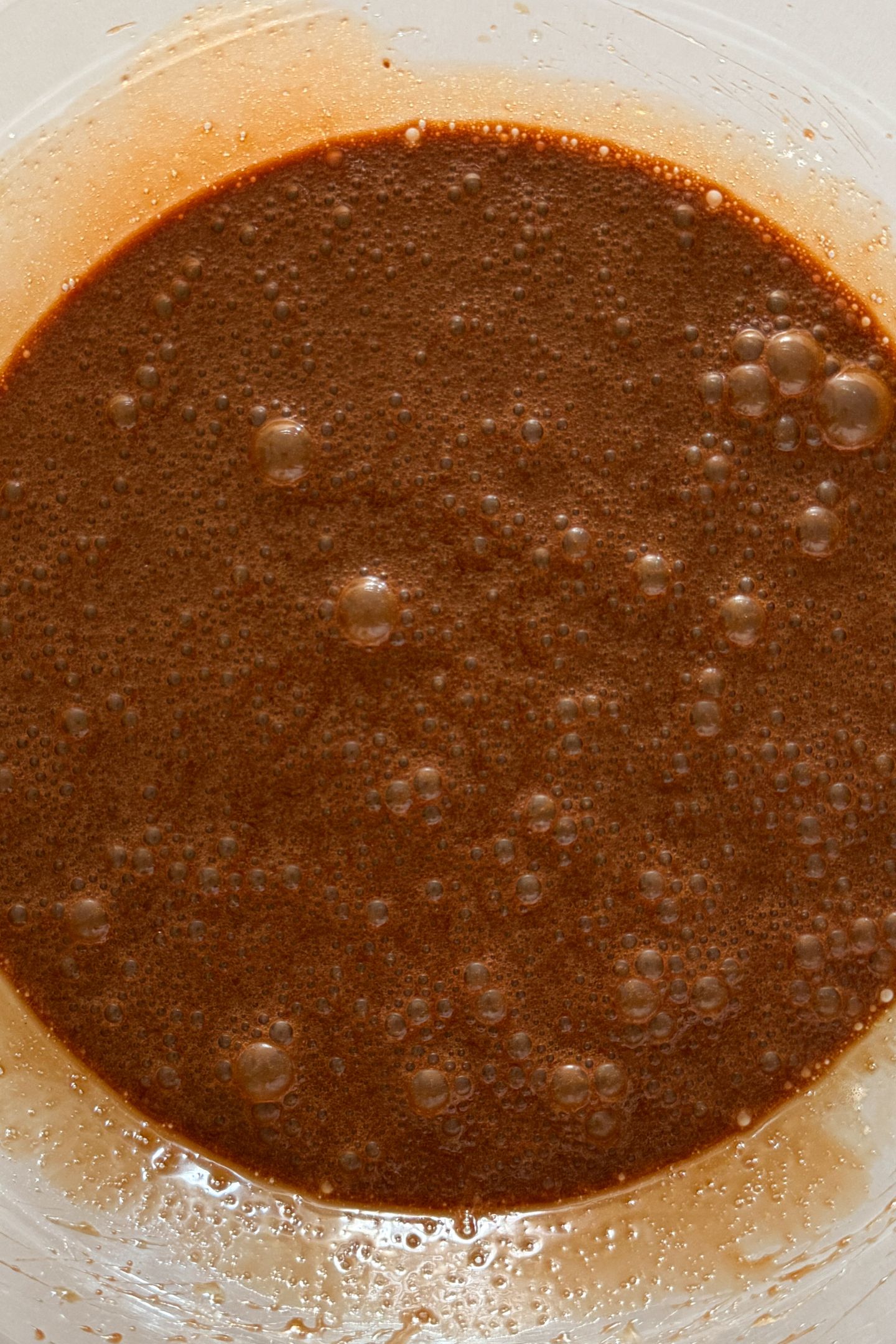 Wet ingredients combined in a bowl with the melted chocolate and butter.