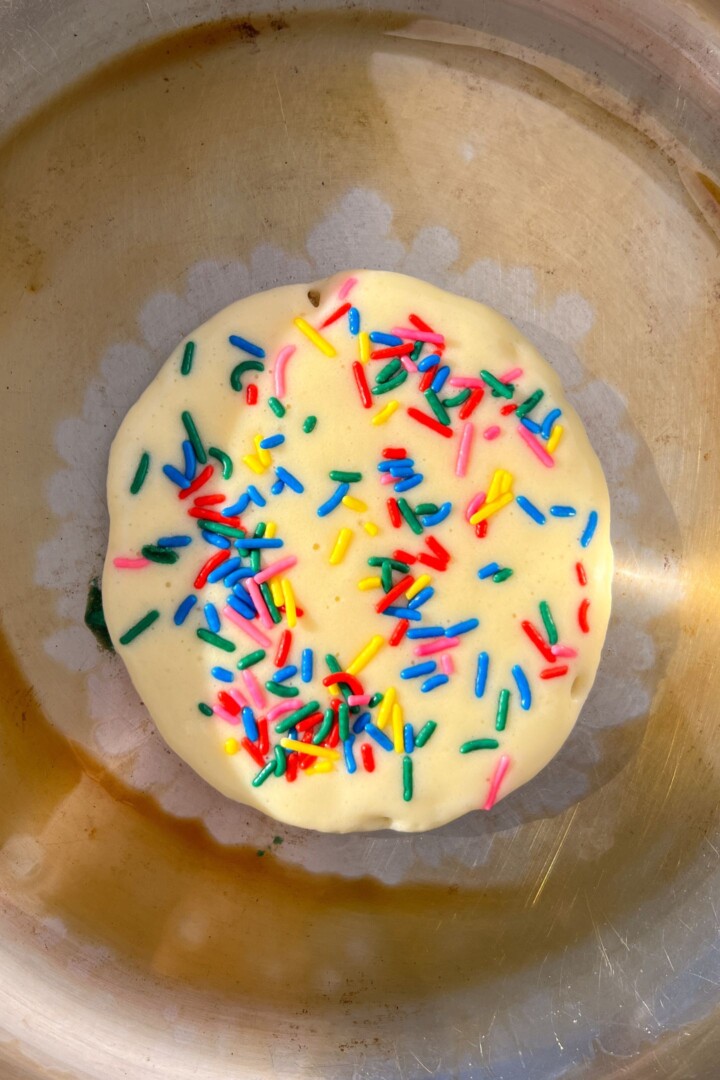 Sprinkles added to pancake batter in pan before flipping.