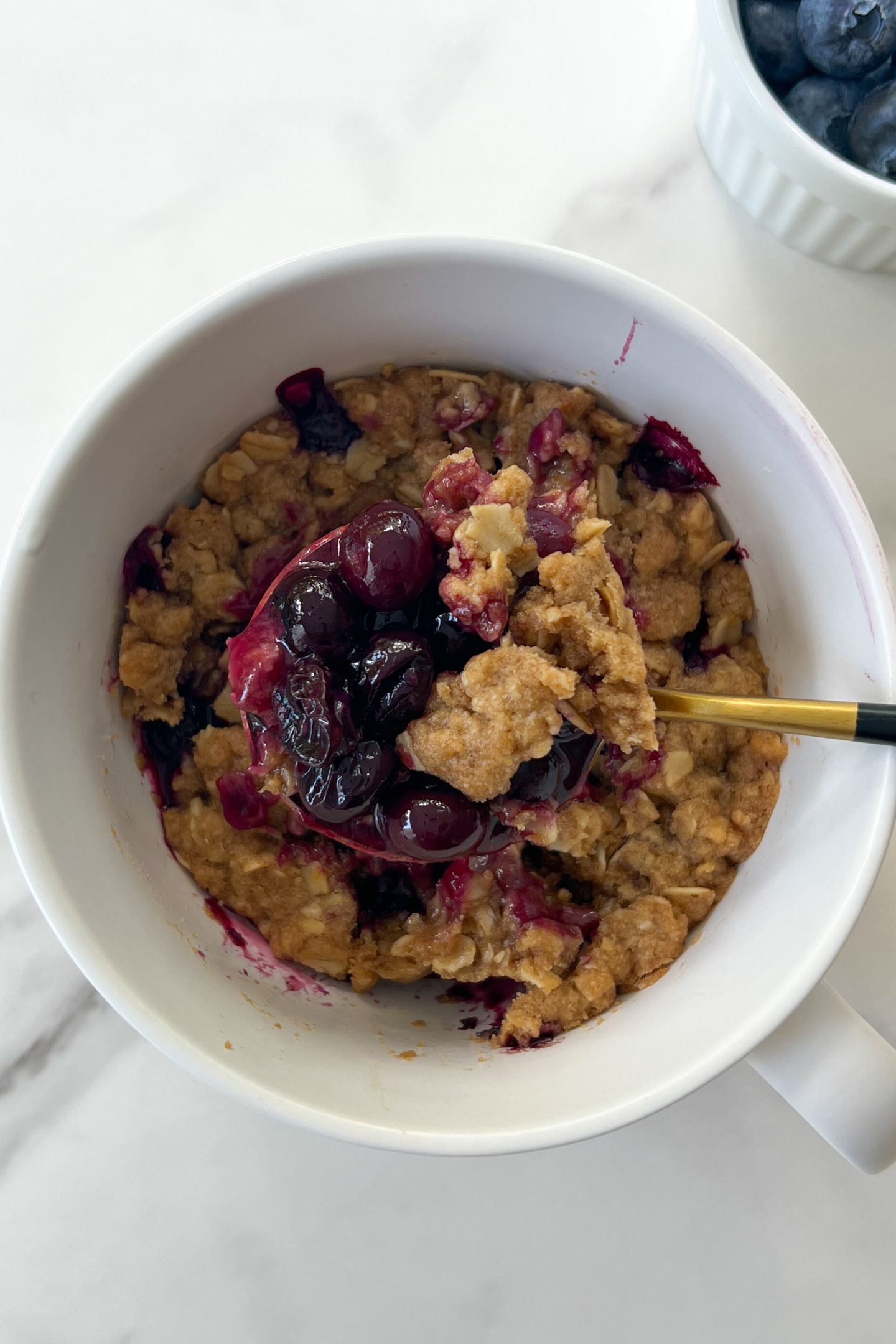 Scooping a blueberry crisp.