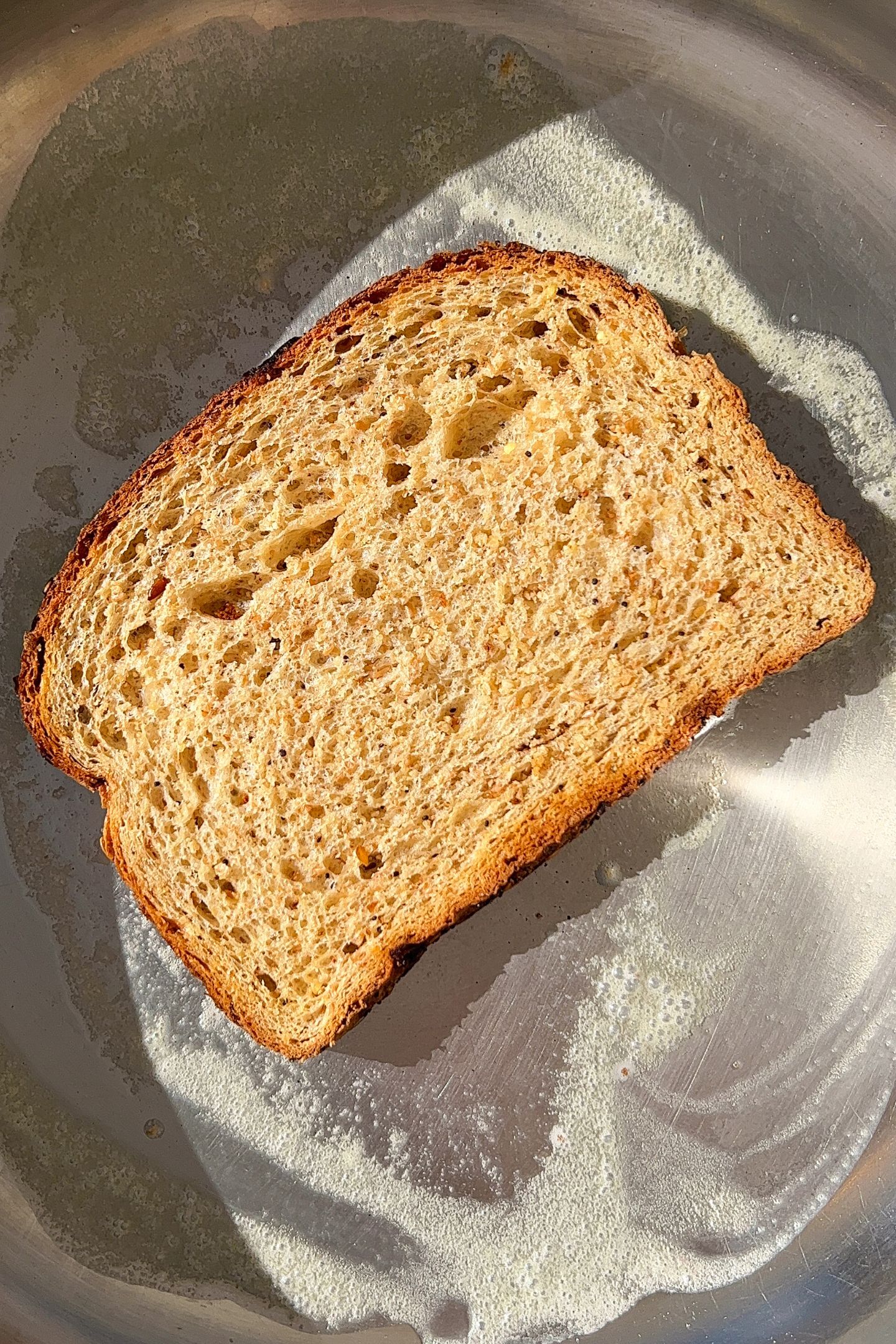 Slice of bread in a heated pan with butter