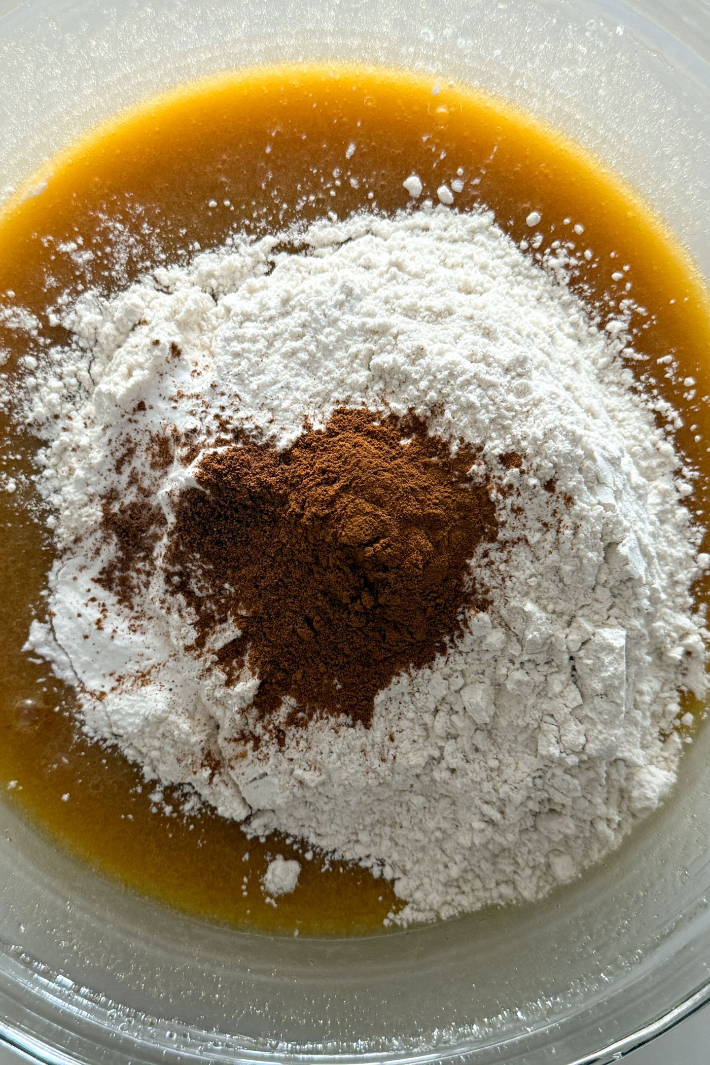 Adding the dry ingredients to the wet ingredients for the gluten-free carrot cake.