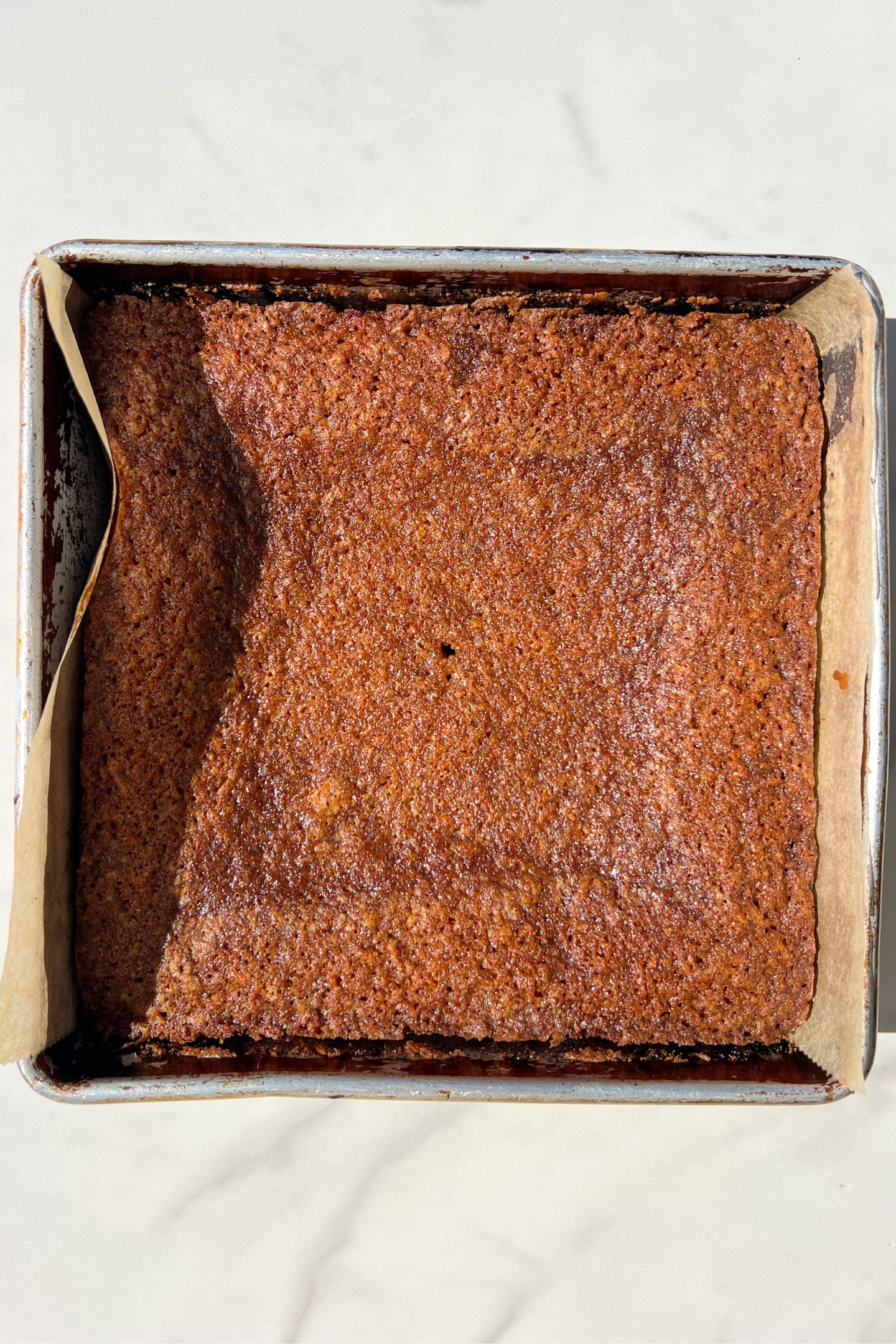 Baked gluten free carrot cake in an 8x8 square baking pan.