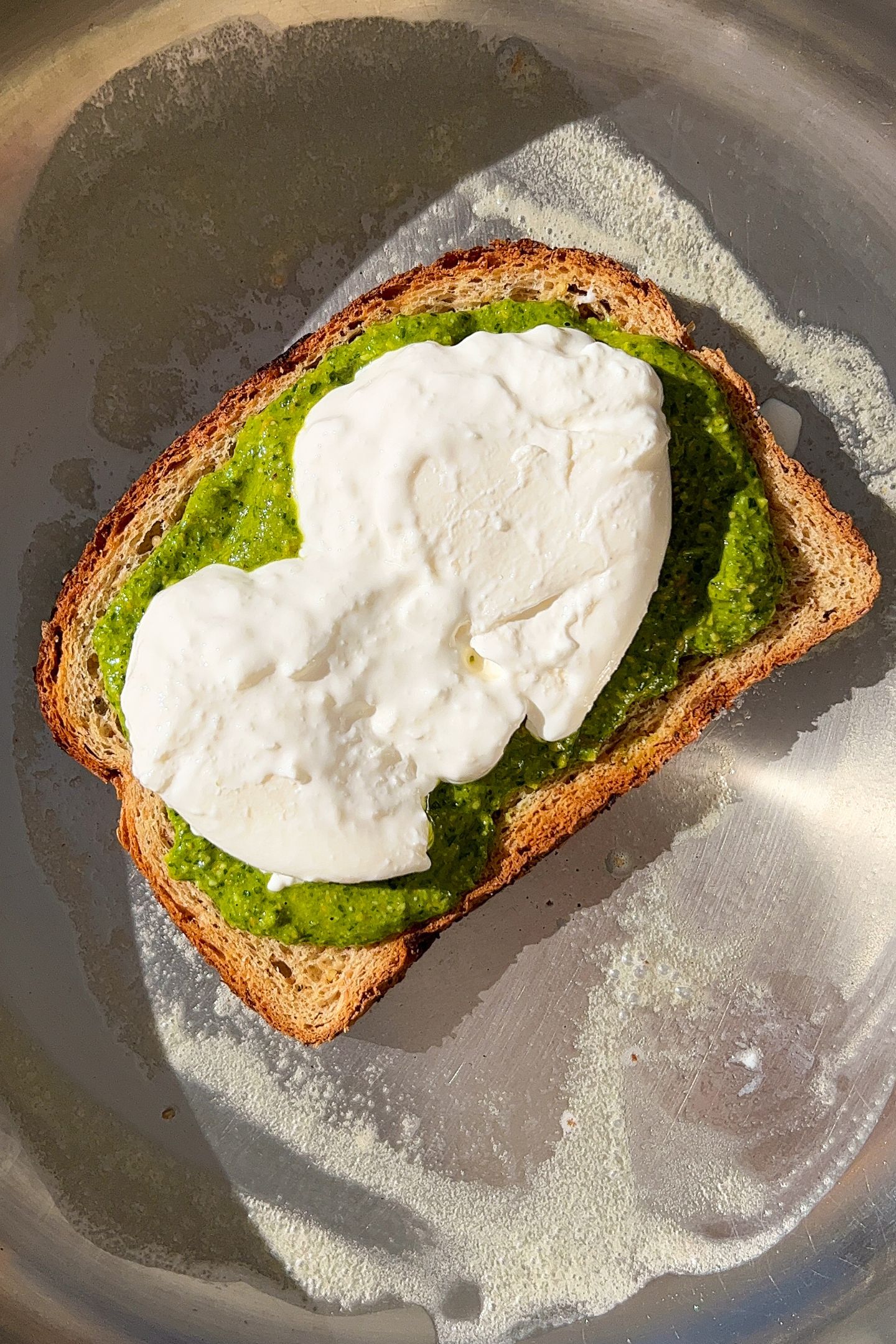 Burrata cheese added on top of the pesto and slice of bread