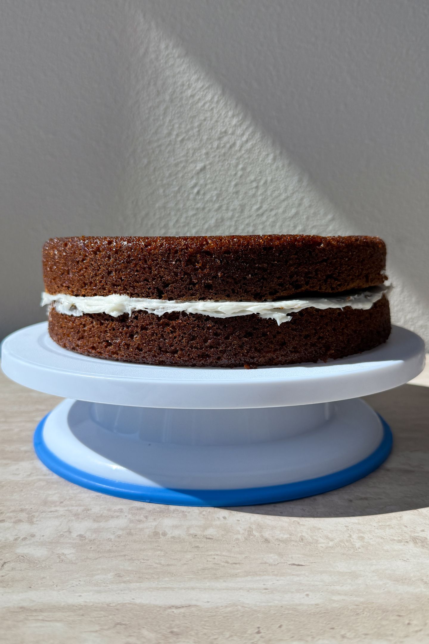 Two carrot cake layers on the cake stand.