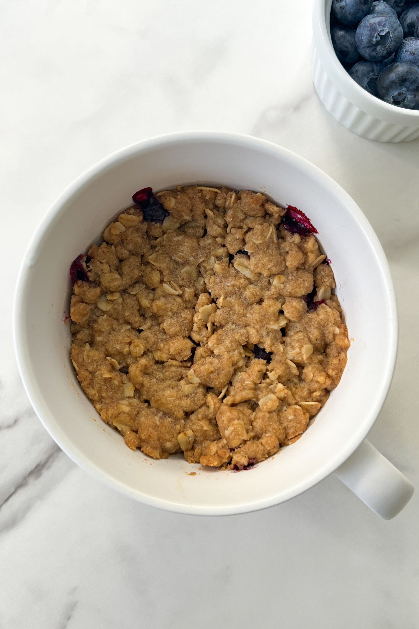 Baked Gluten Free Blueberry Crisp in an oven-safe mug