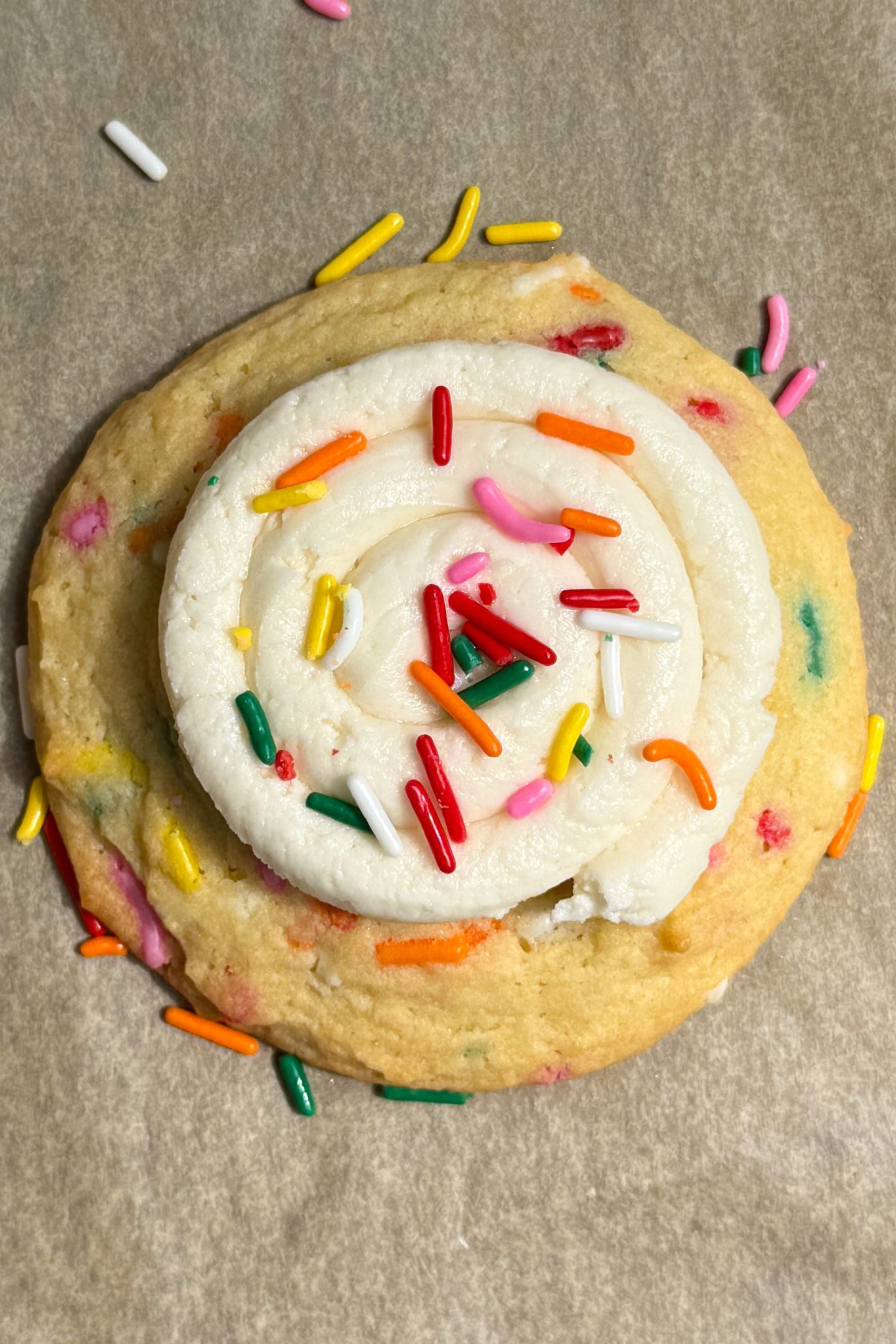 A Birthday Cake Cookie topped with buttercream frosting and sprinkles.