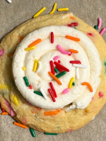 A Birthday Cake Cookie topped with buttercream frosting and sprinkles.