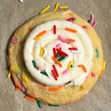 A Birthday Cake Cookie topped with buttercream frosting and sprinkles.