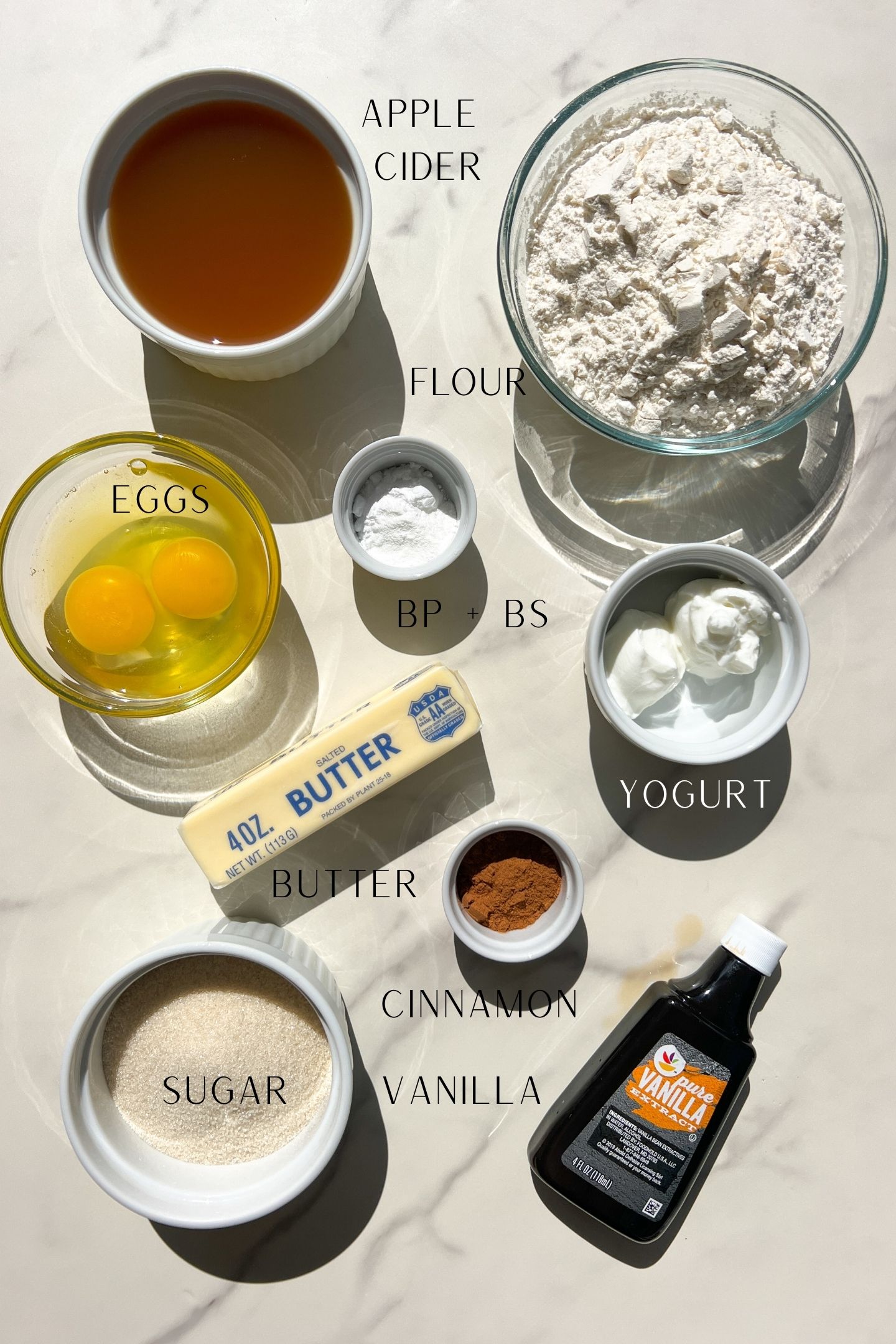 Apple cider muffin ingredients measured out in bowls.