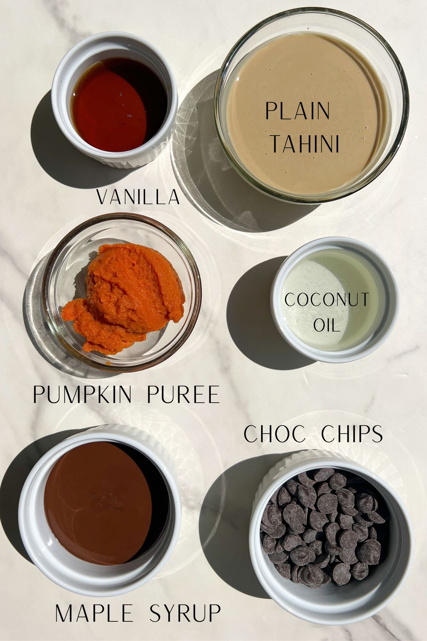 Ingredients to make chocolate and pumpkin fudge measured out in bowls.