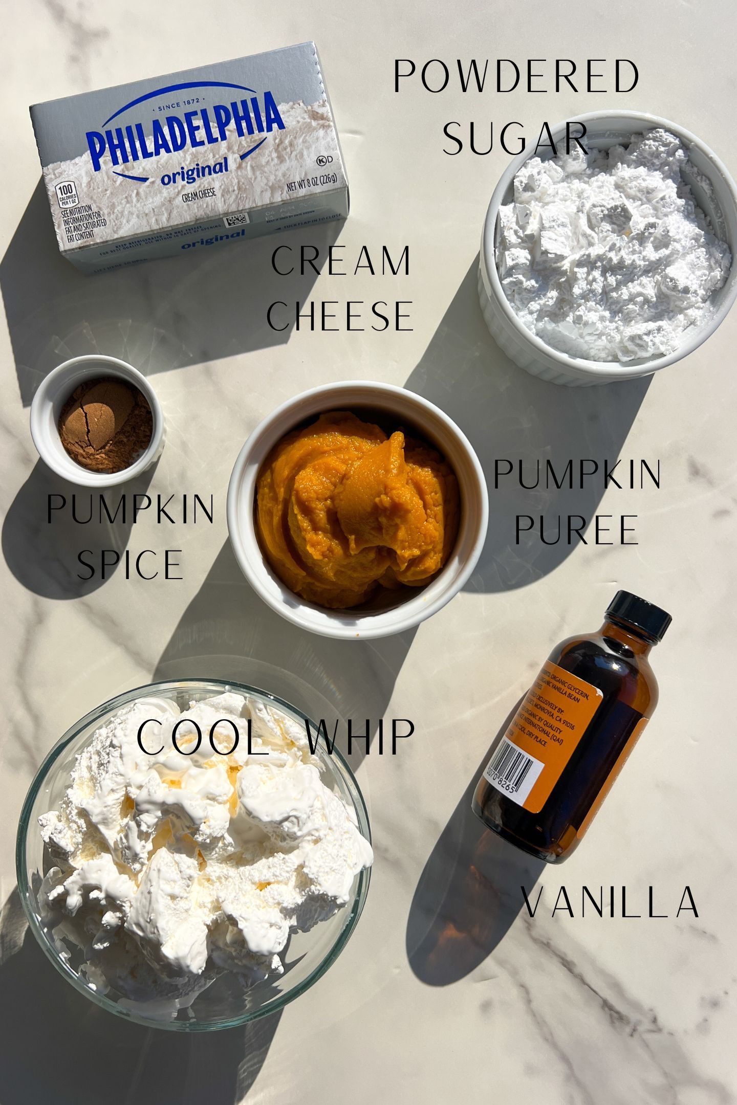 Pumpkin Cheesecake ingredients measured out in bowls.