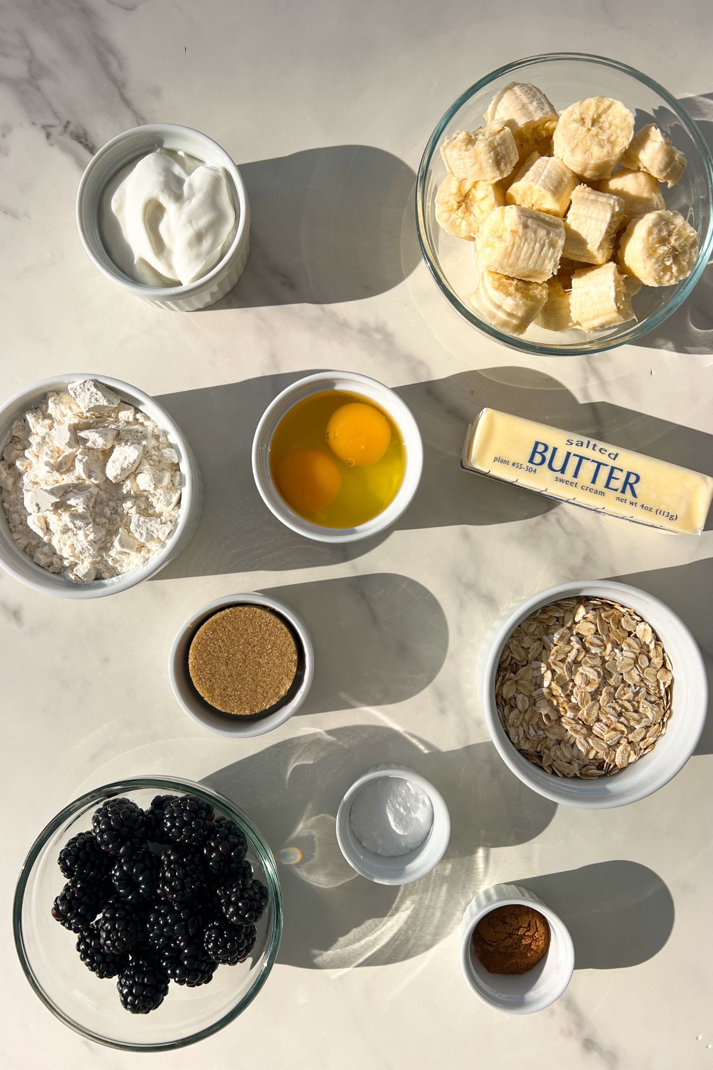 Ingredients measured out in bowls to make the blackberry, banana and oatmeal muffins.
