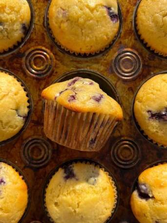 Lemon Blueberry Muffin freshly baked on its side in the muffin tin.