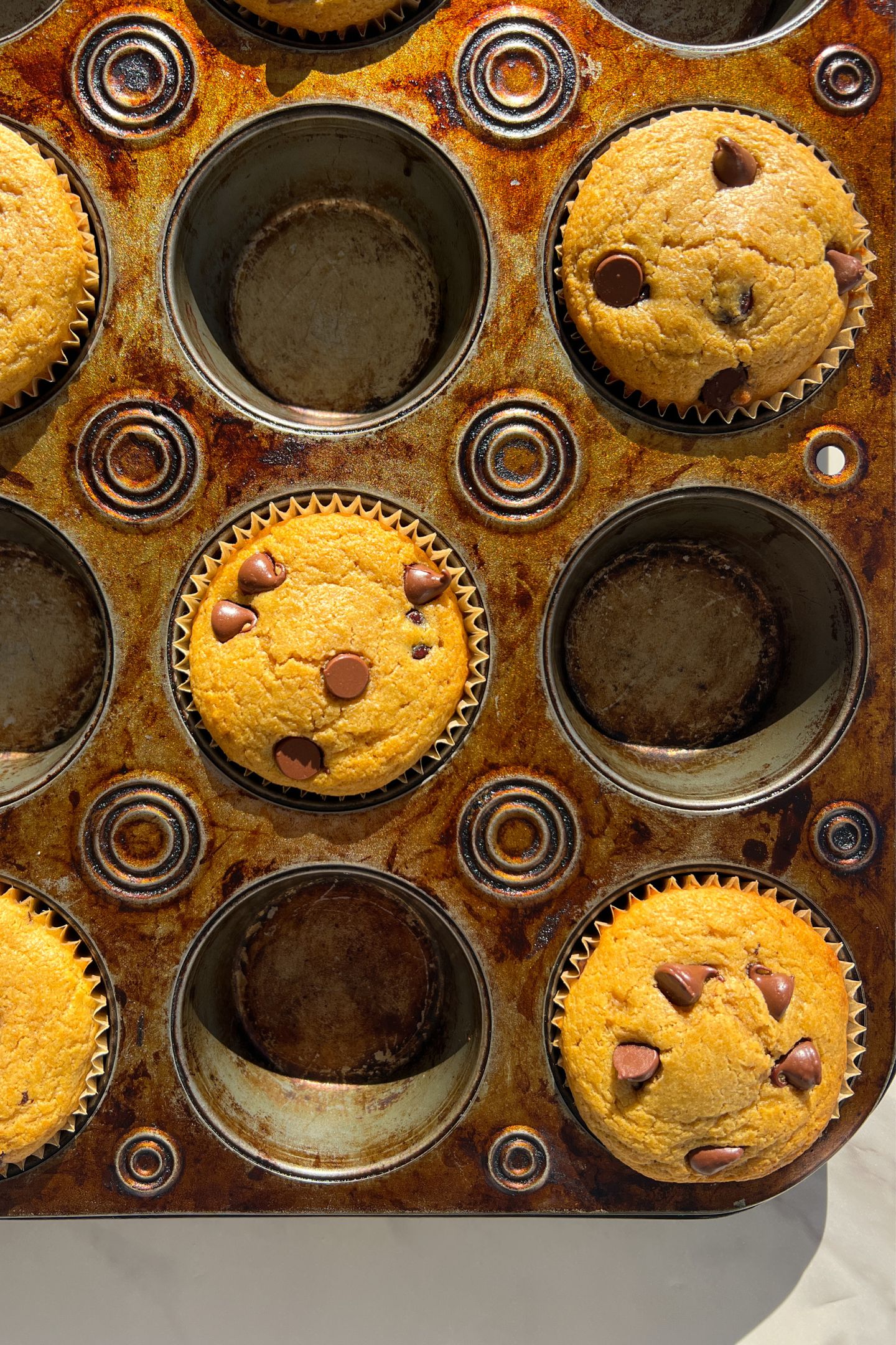 Baked pancake chocolate chip muffins in a baking tray.