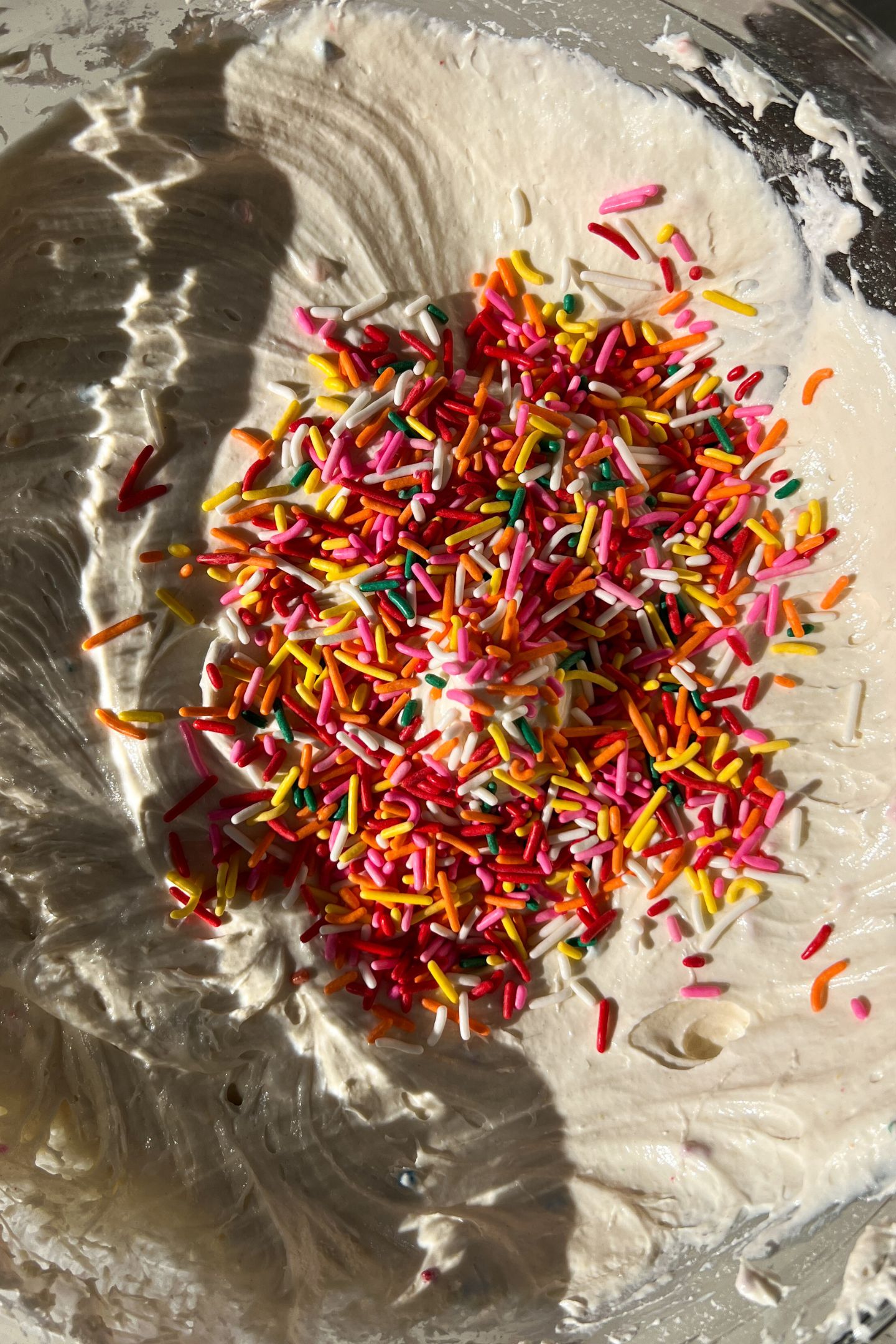 Funfetti Cake Dip blended in a bowl topped with sprinkles before folded into the batter.