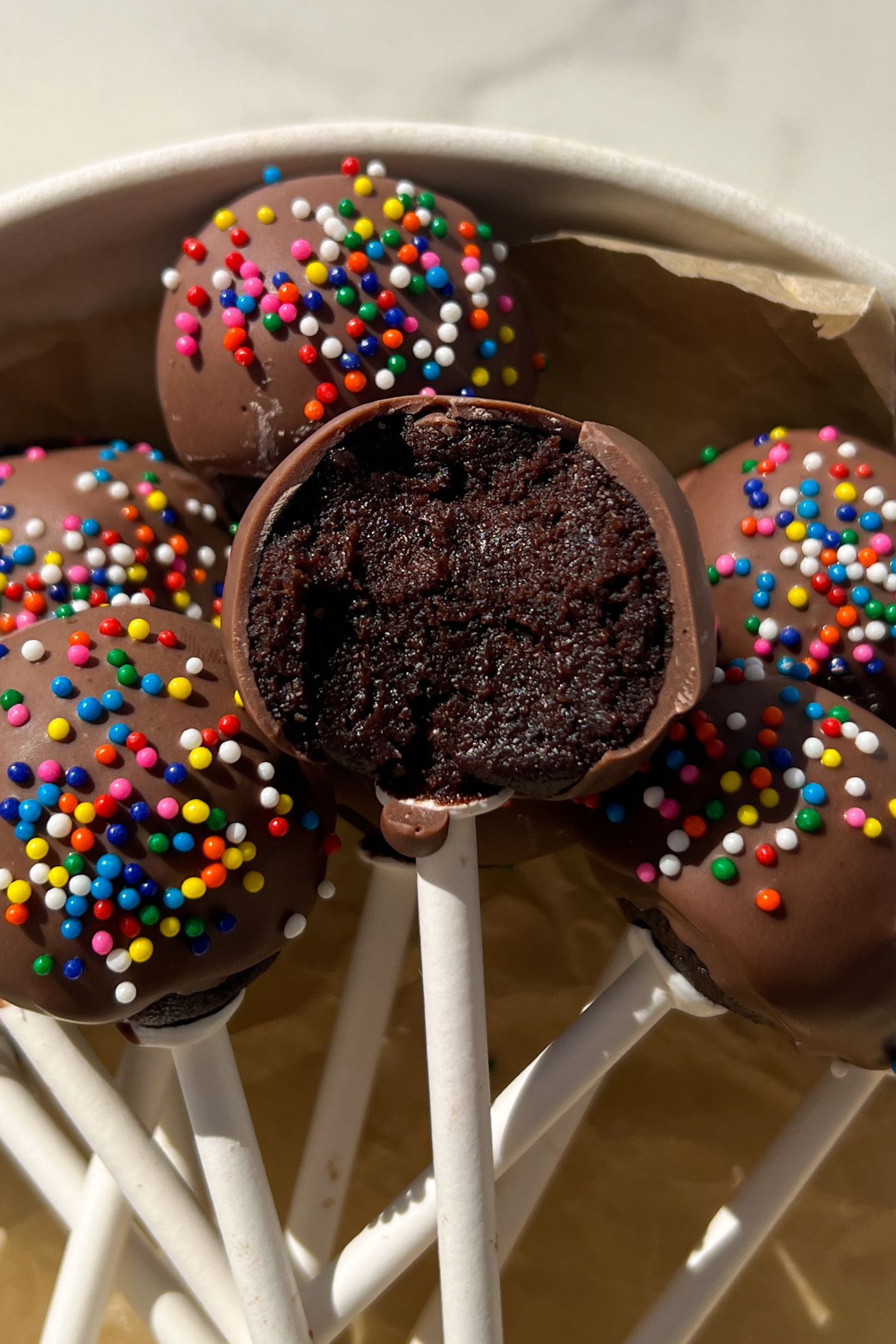 A cake pop with a bite taken out of it.