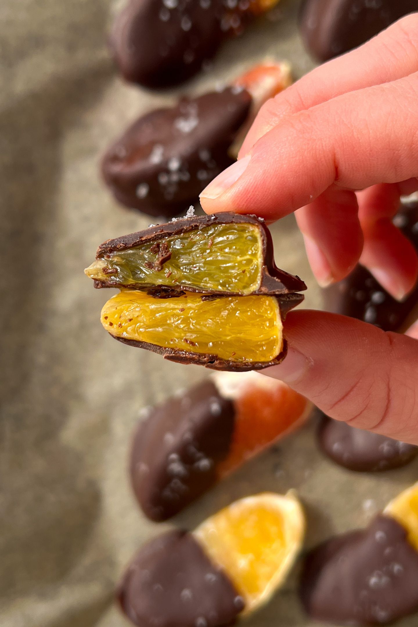 Holding a chocolate orange slice cut in half.