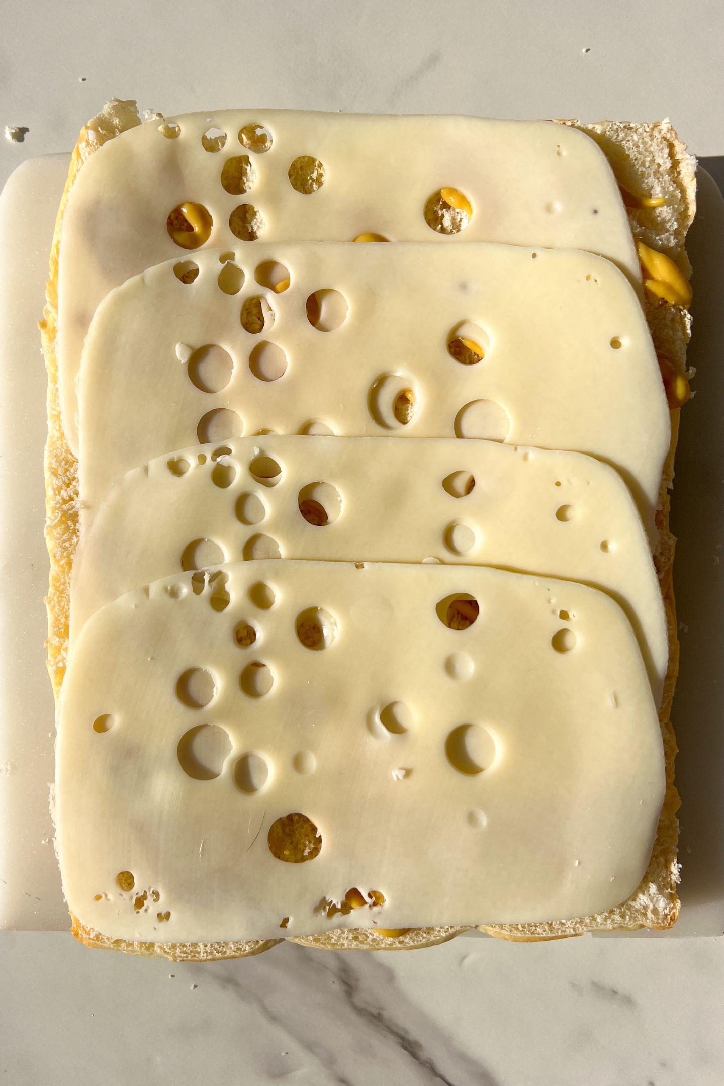Swiss cheese slices on top of the mustard.