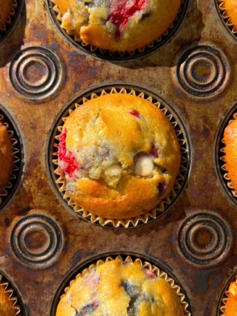 Baked Raspberry White Chocolate Muffins in a muffin tin.