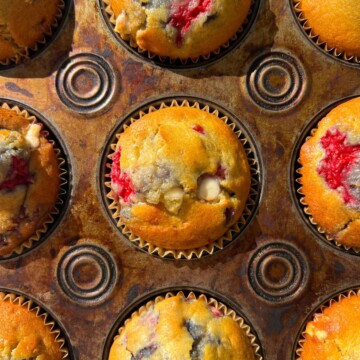 Baked Raspberry White Chocolate Muffins in a muffin tin.