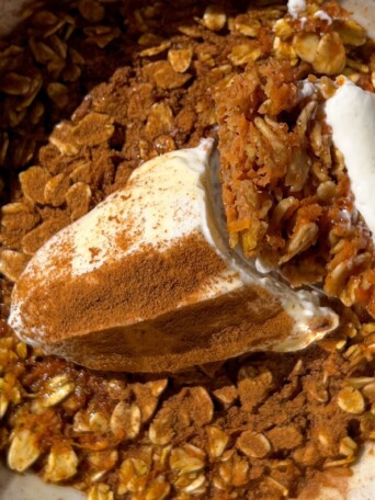 A bowl of carrot cake baked oatmeal with yogurt and cinnamon.