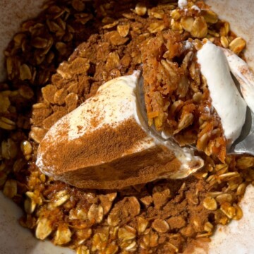 A bowl of carrot cake baked oatmeal with yogurt and cinnamon.