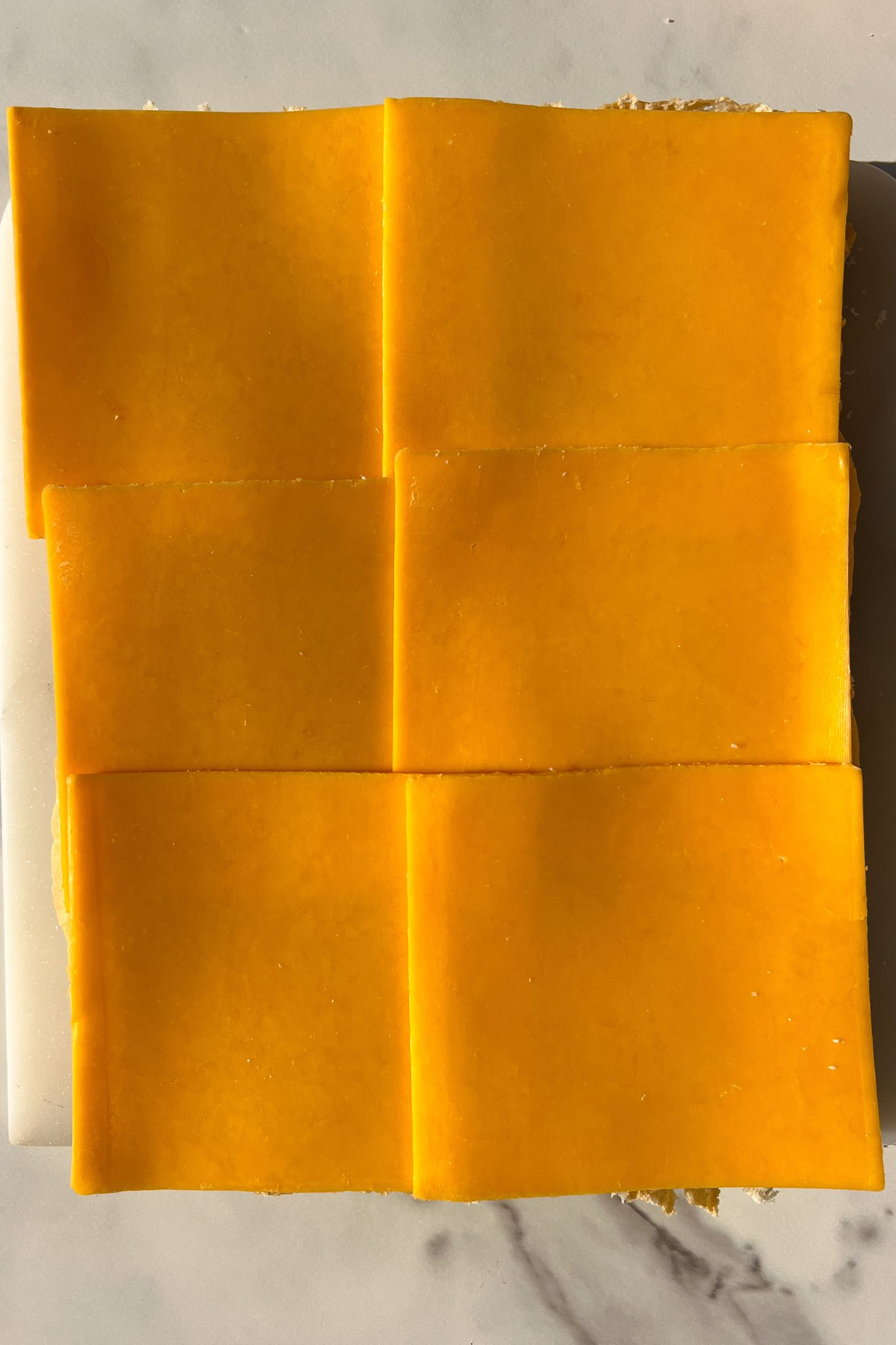 Hawaiian Rolls topped with slices of sharp cheddar cheese.