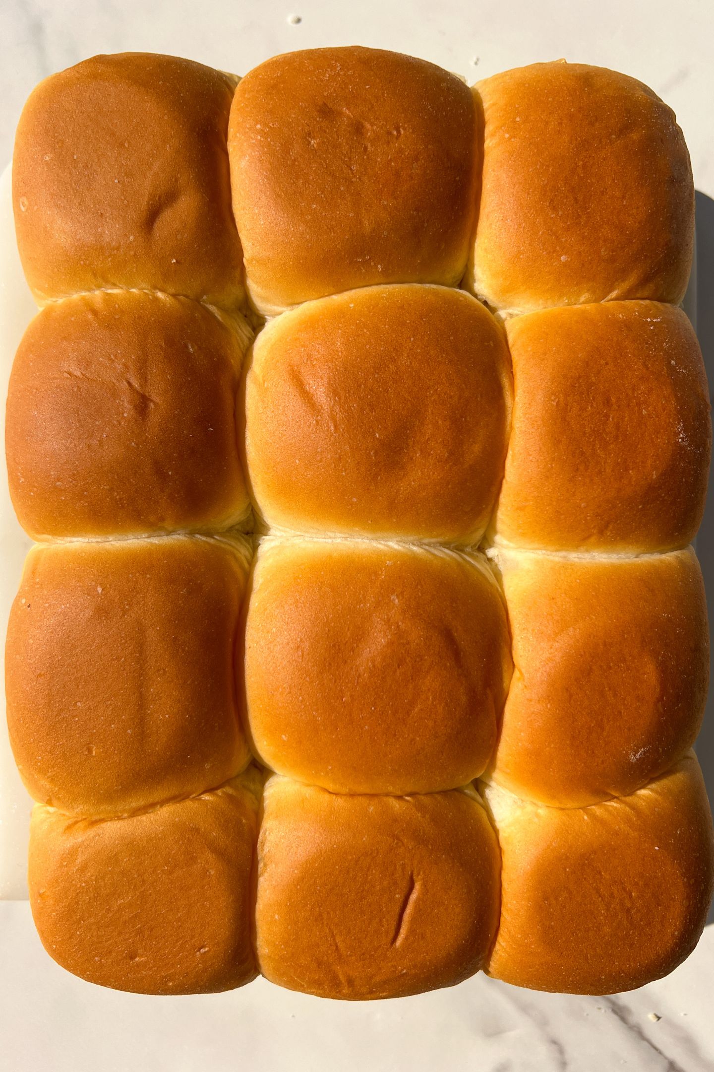 Top layer of the Hawaiian Rolls on the cheeseburger layers. 