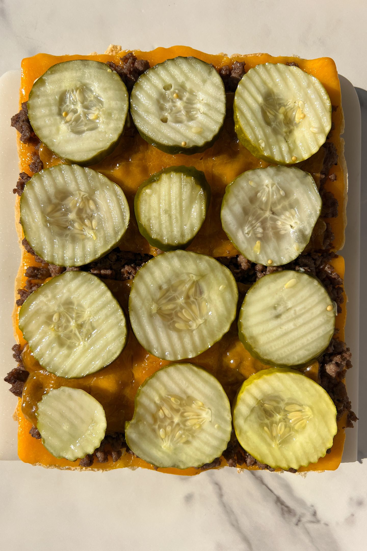 Butter pickles on top of cheese.