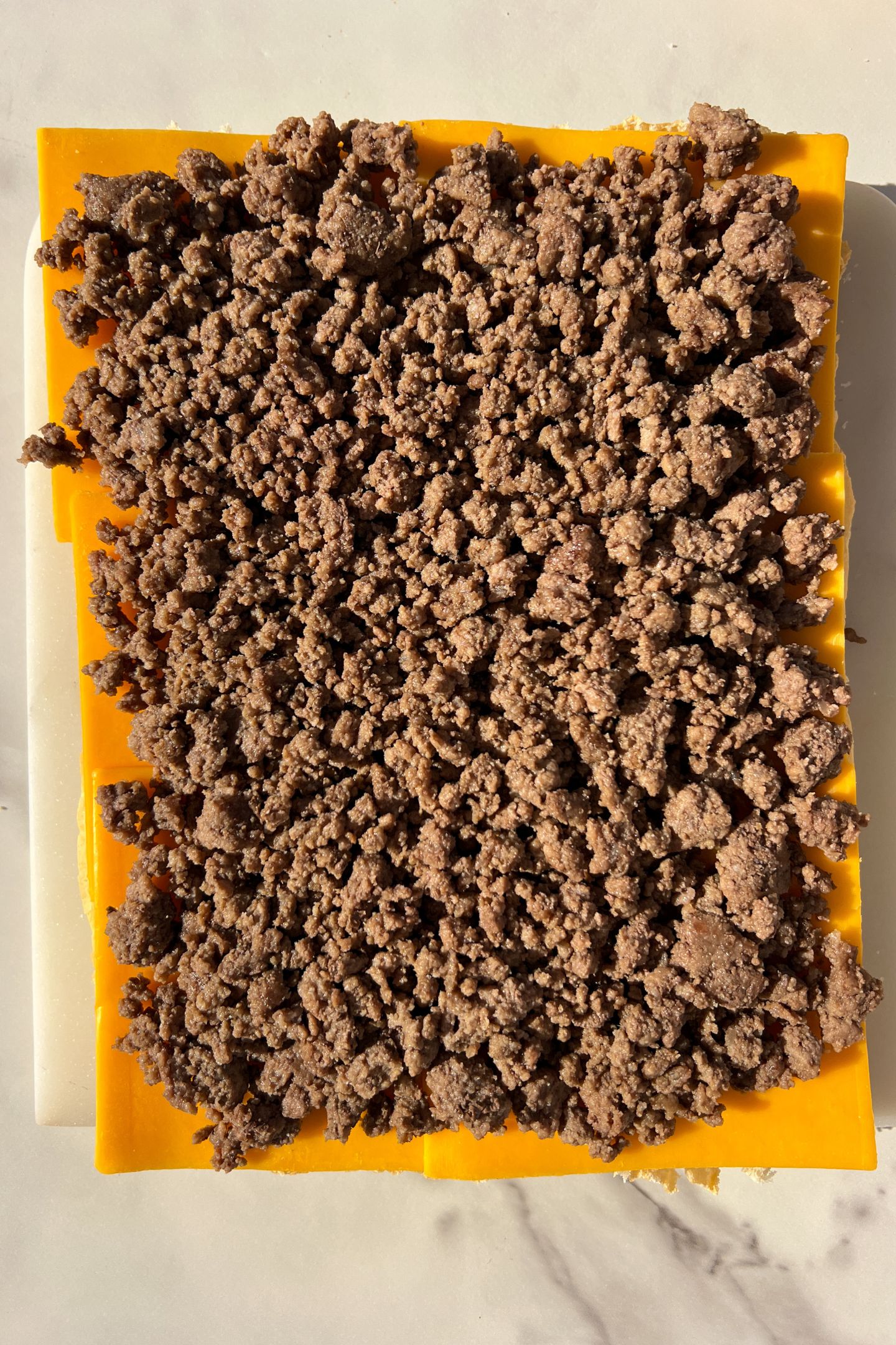 Cooked ground beef on top of the cheese layer.