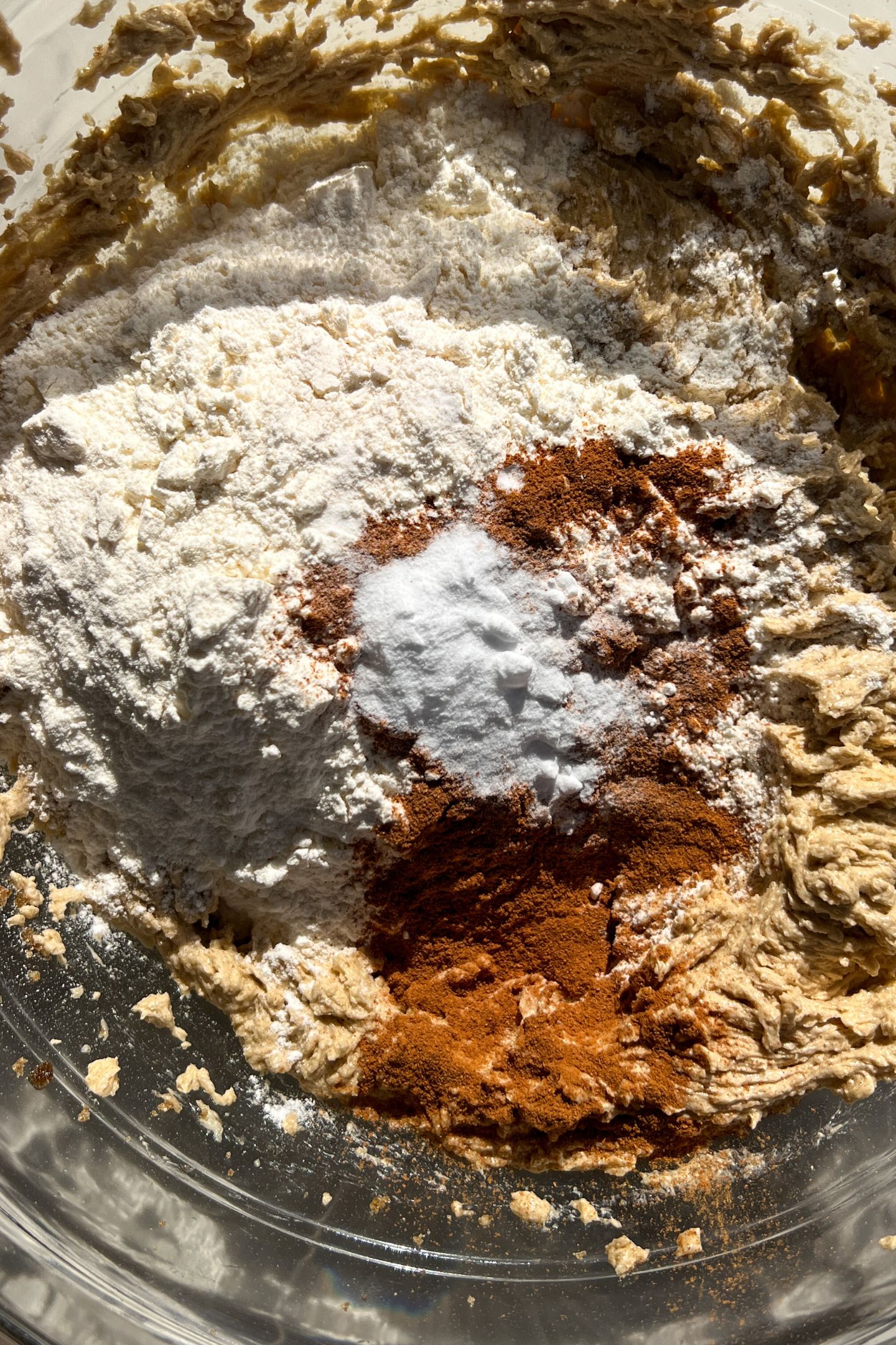 Adding dry ingredients to batter in mixing bowl.