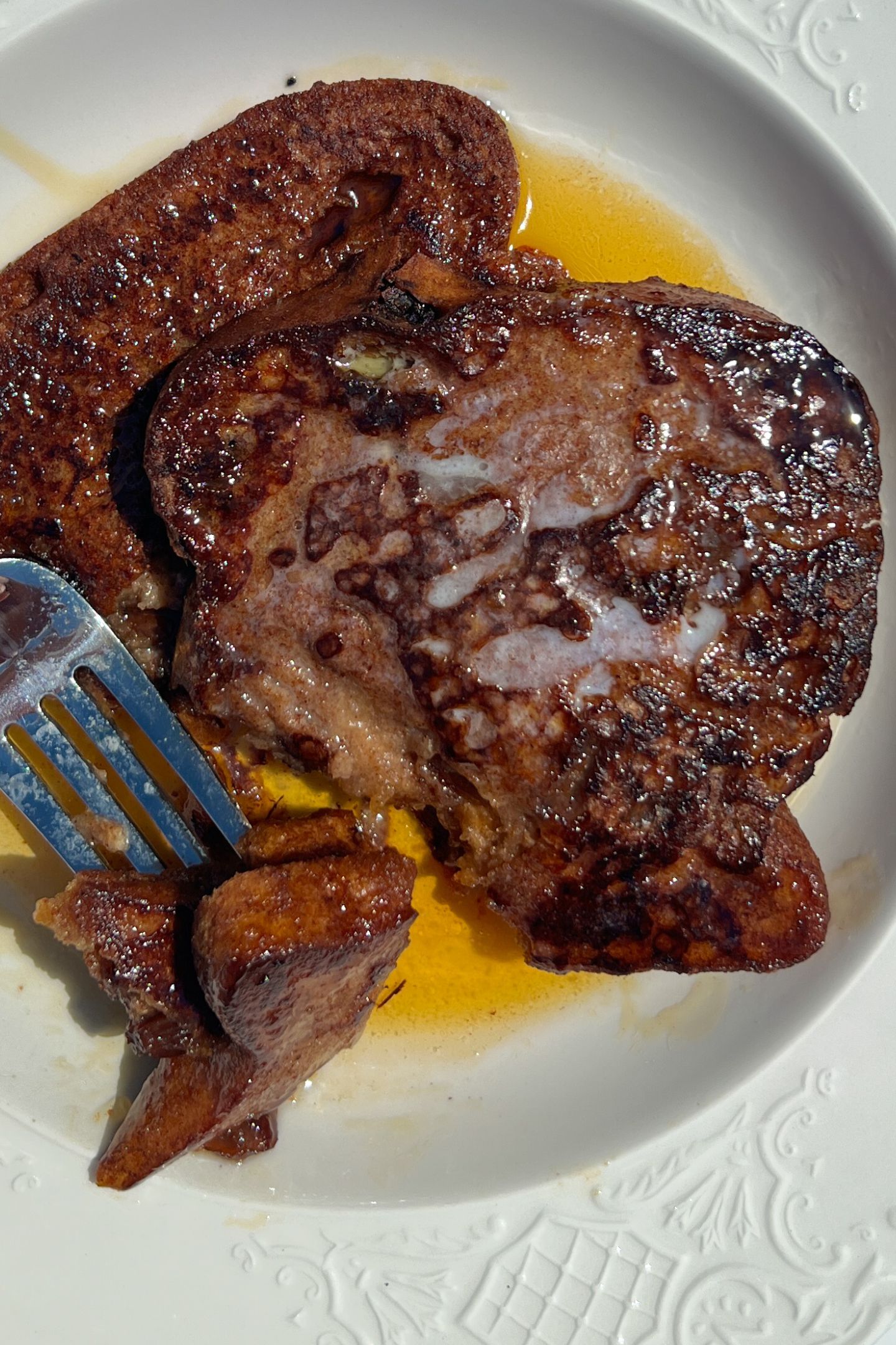 French toast on a plate with butter and maple syrup.