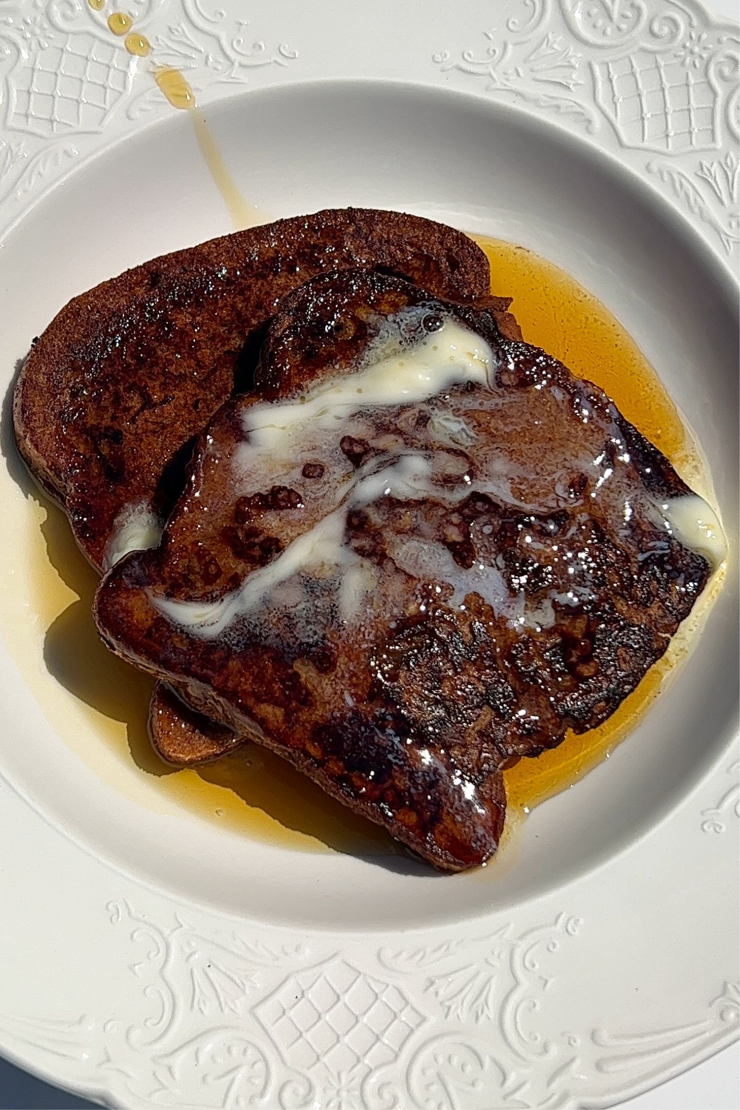 Gluten free cinnamon raisin French toast on a plate with toppings.