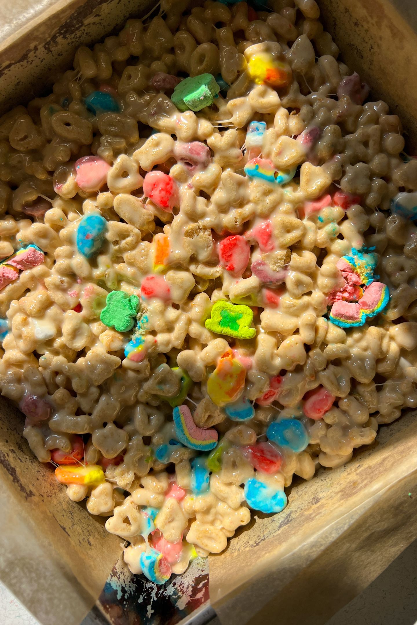 Lucky Charms Rice Krispie Treats setting in the prepared pan.