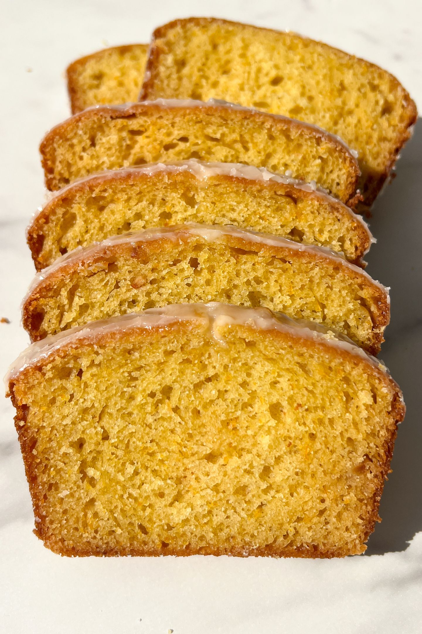 Slices of Glazed Orange Loaf stacked on each other.