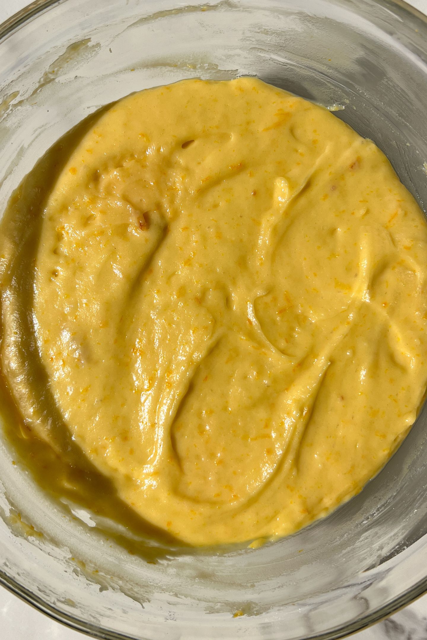 Orange loaf batter in a mixing bowl after resting for 30 minutes.