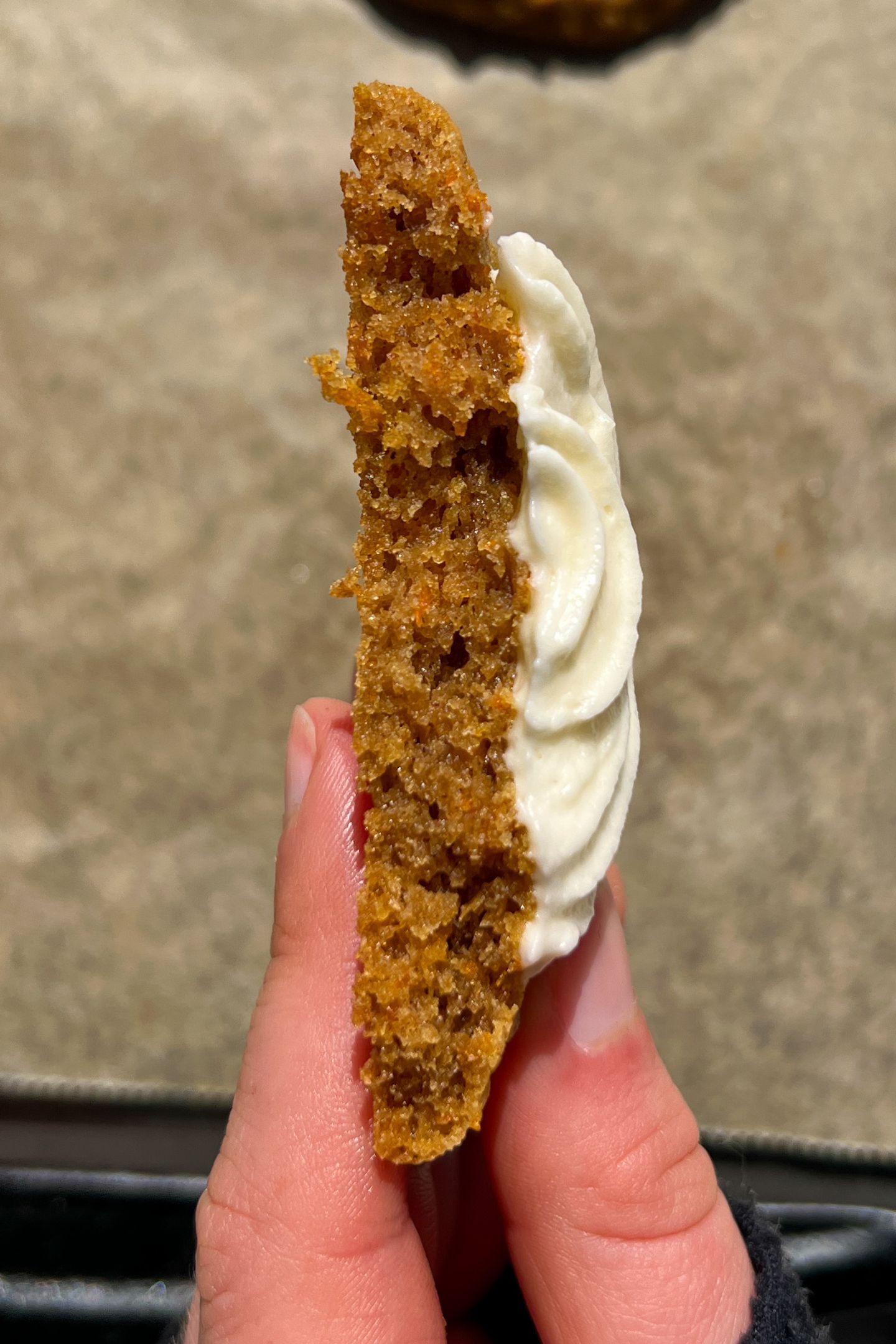 Holding half of a carrot cake cookie in my hand to show the inside texture. 