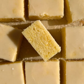 Sliced Lemon Brownies topped with the glaze and one on it's side.