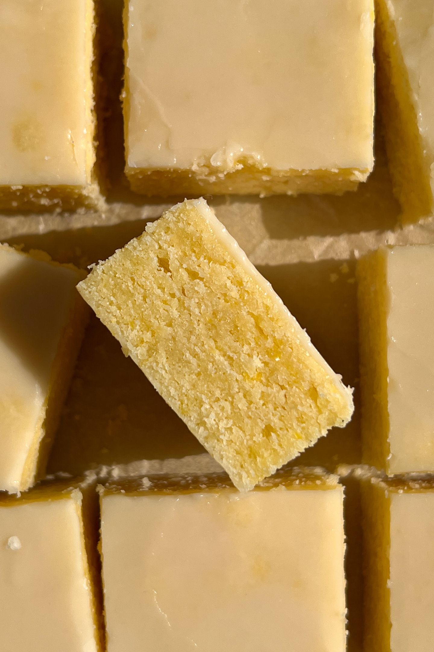 Sliced Lemon Brownies topped with the glaze and one on it's side.