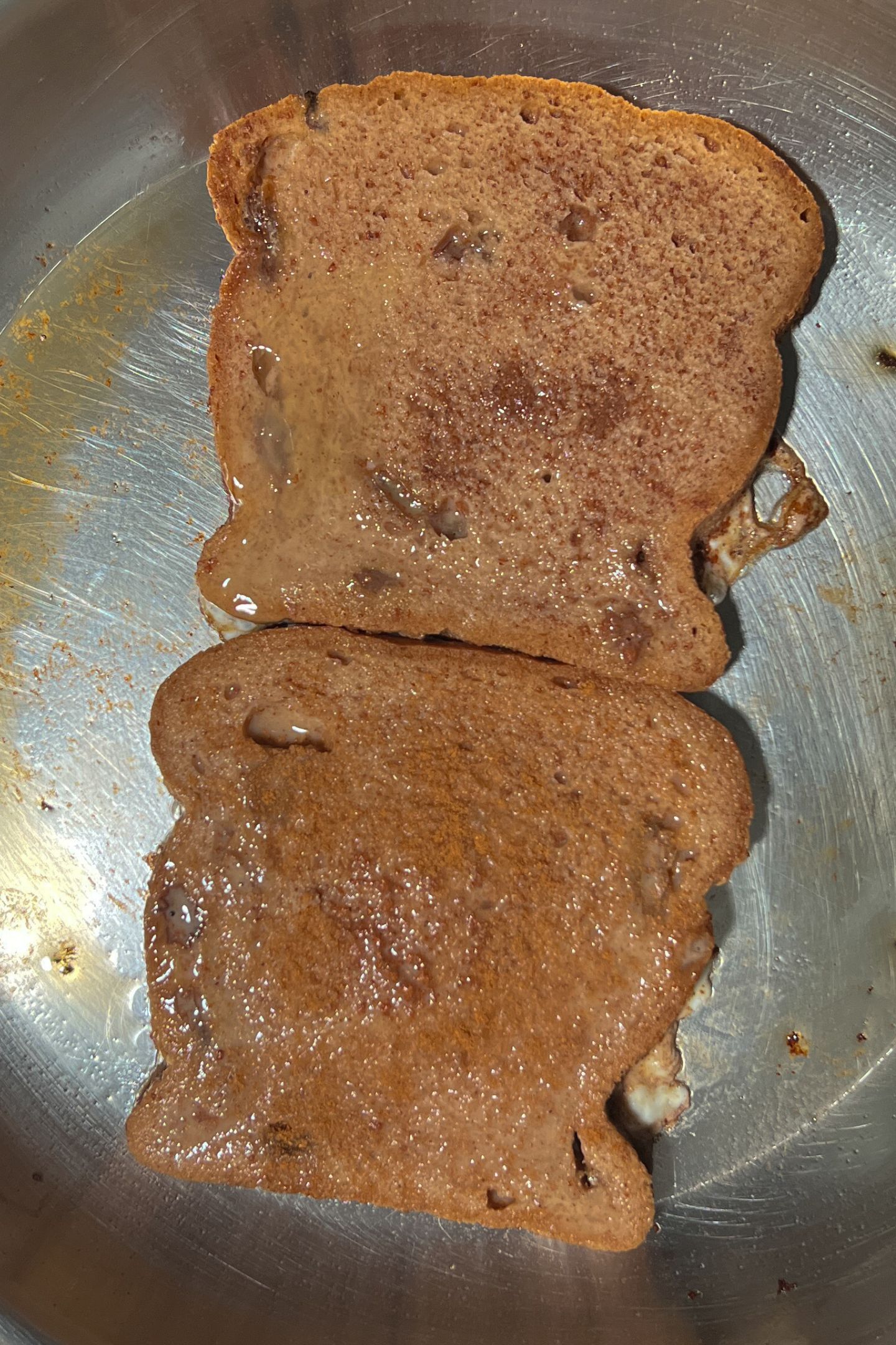 Uncooked French toasted in a heated pan.
