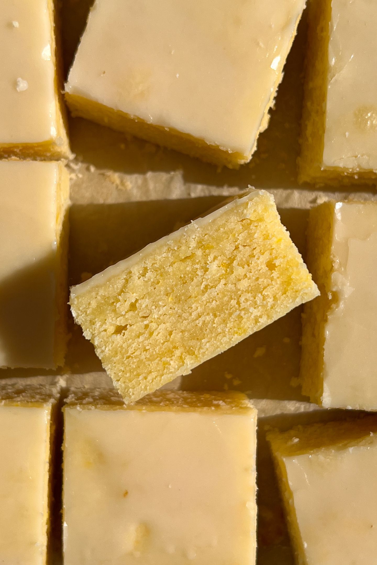 Sliced Lemon Brownies topped with the glaze and one on it's side.