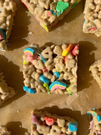 Sliced Rice Krispie Treats made with Lucky Charms cereal on parchment paper.