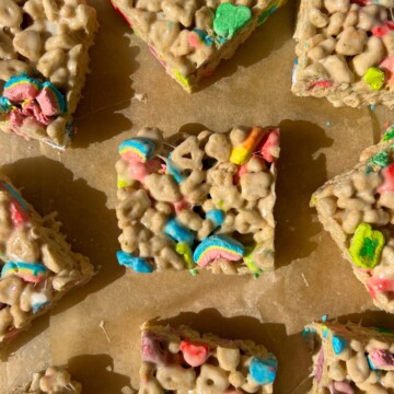 Sliced Rice Krispie Treats made with Lucky Charms cereal on parchment paper.