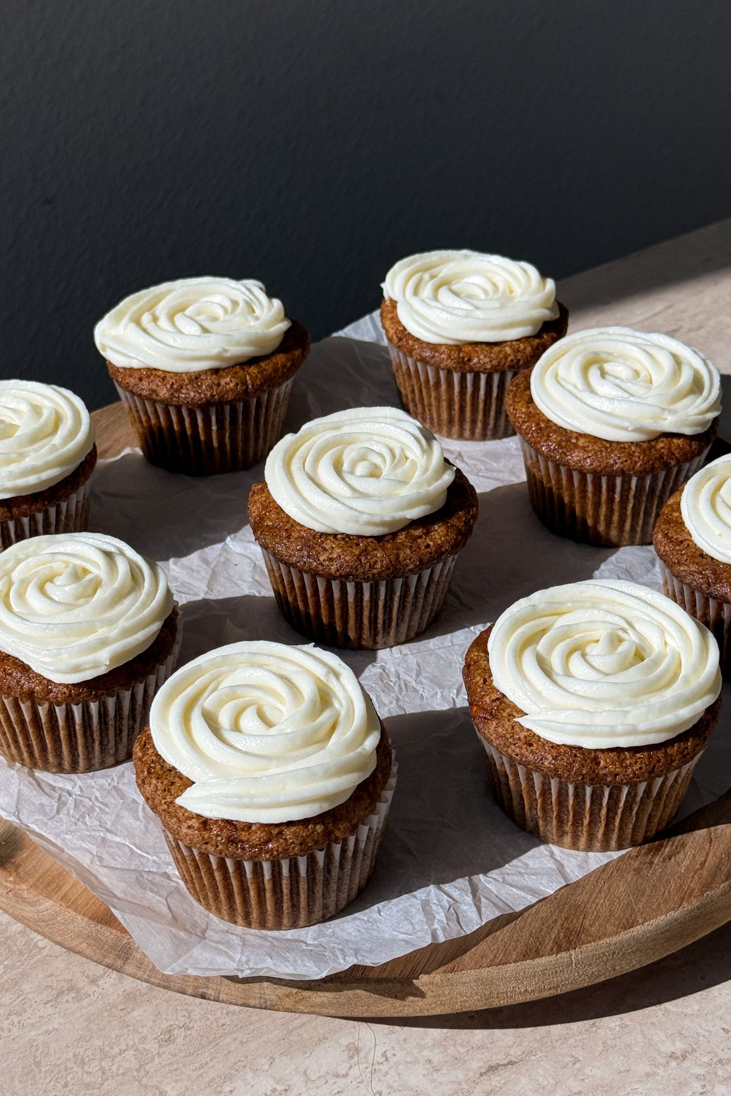 Frosted gluten free carrot cake cupcakes on a serving platter.