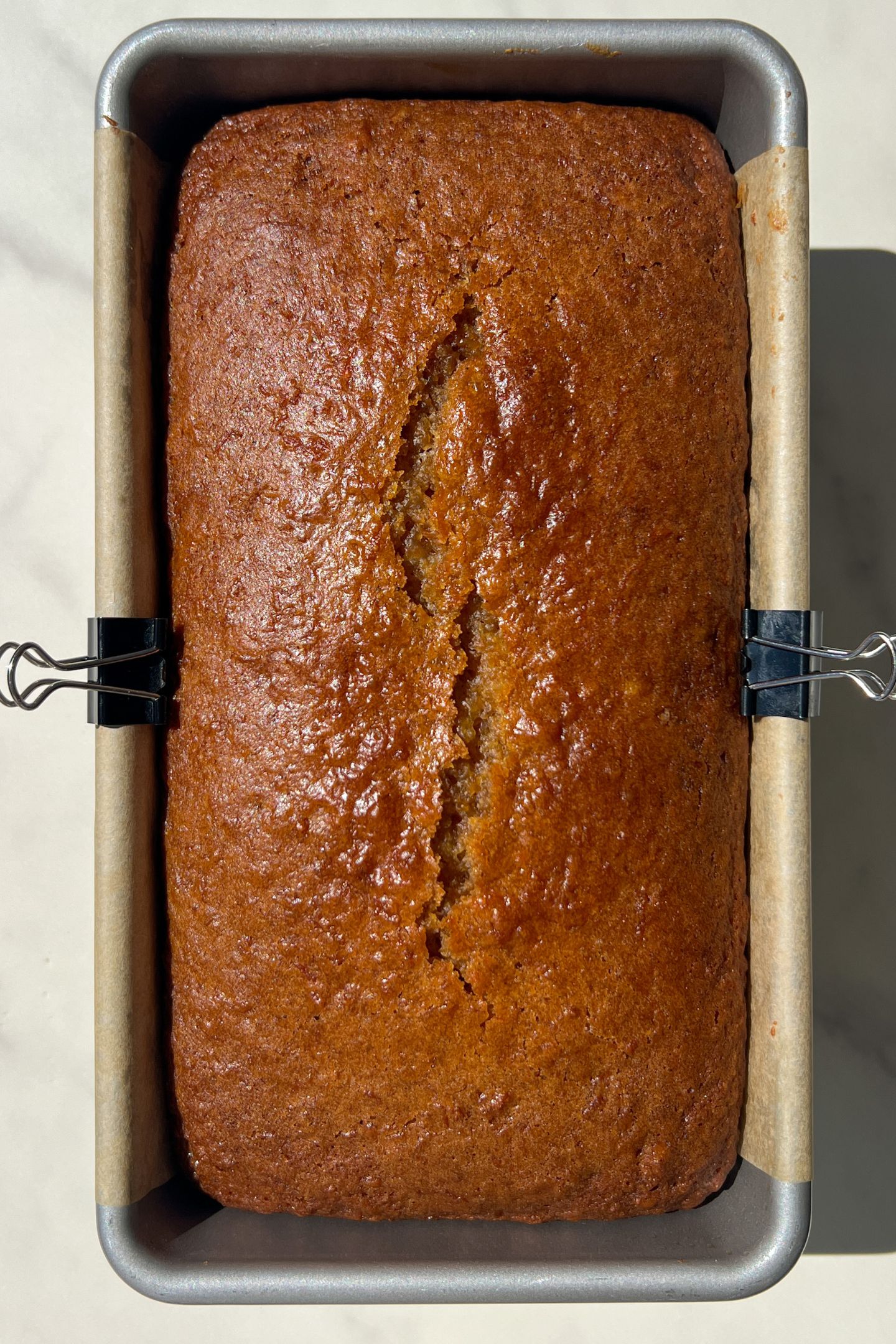 Baked Carrot Loaf Cake in a loaf pan lined with parchment paper. 