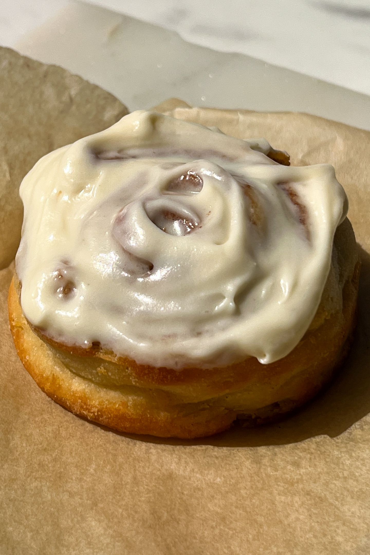 Protein Cinnamon Roll topped with a vanilla cream cheese frosting.