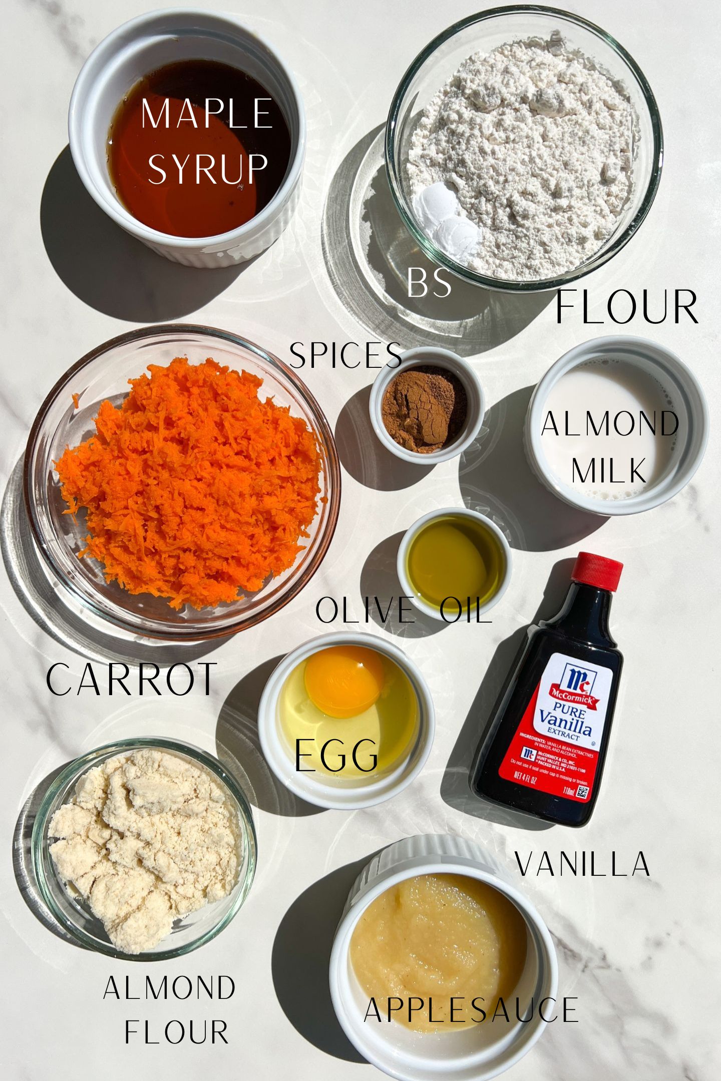 Ingredients measured out in bowls to make carrot cake muffins.