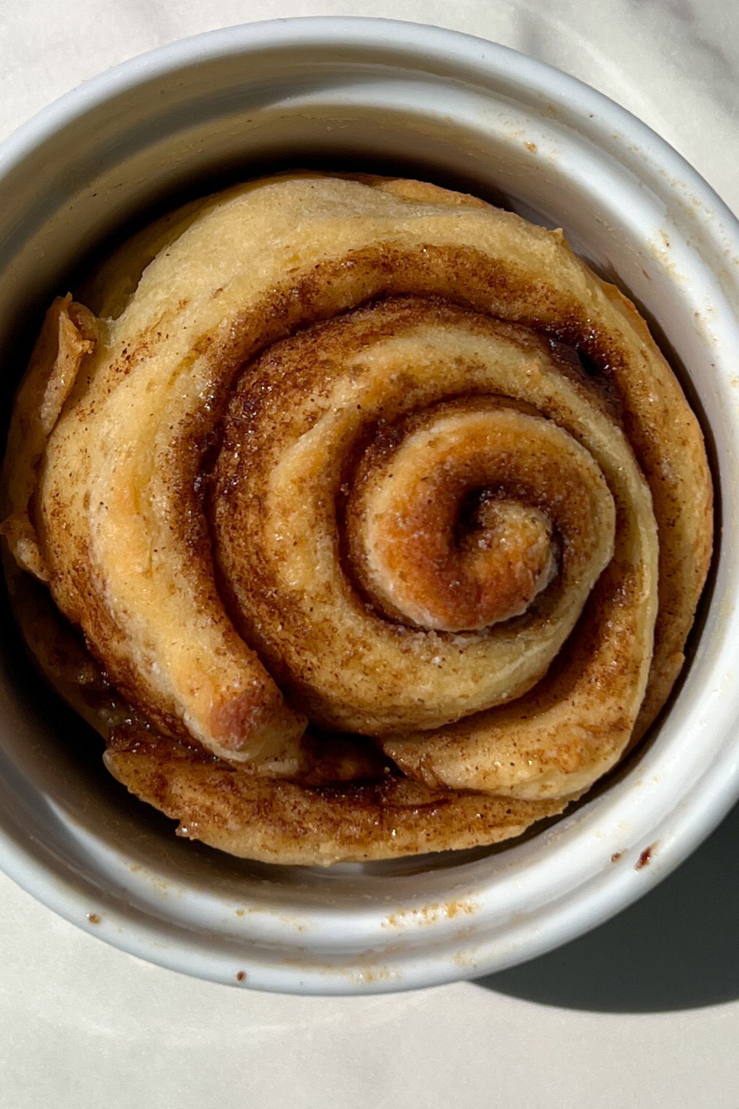 The baked cinnamon roll in dish.