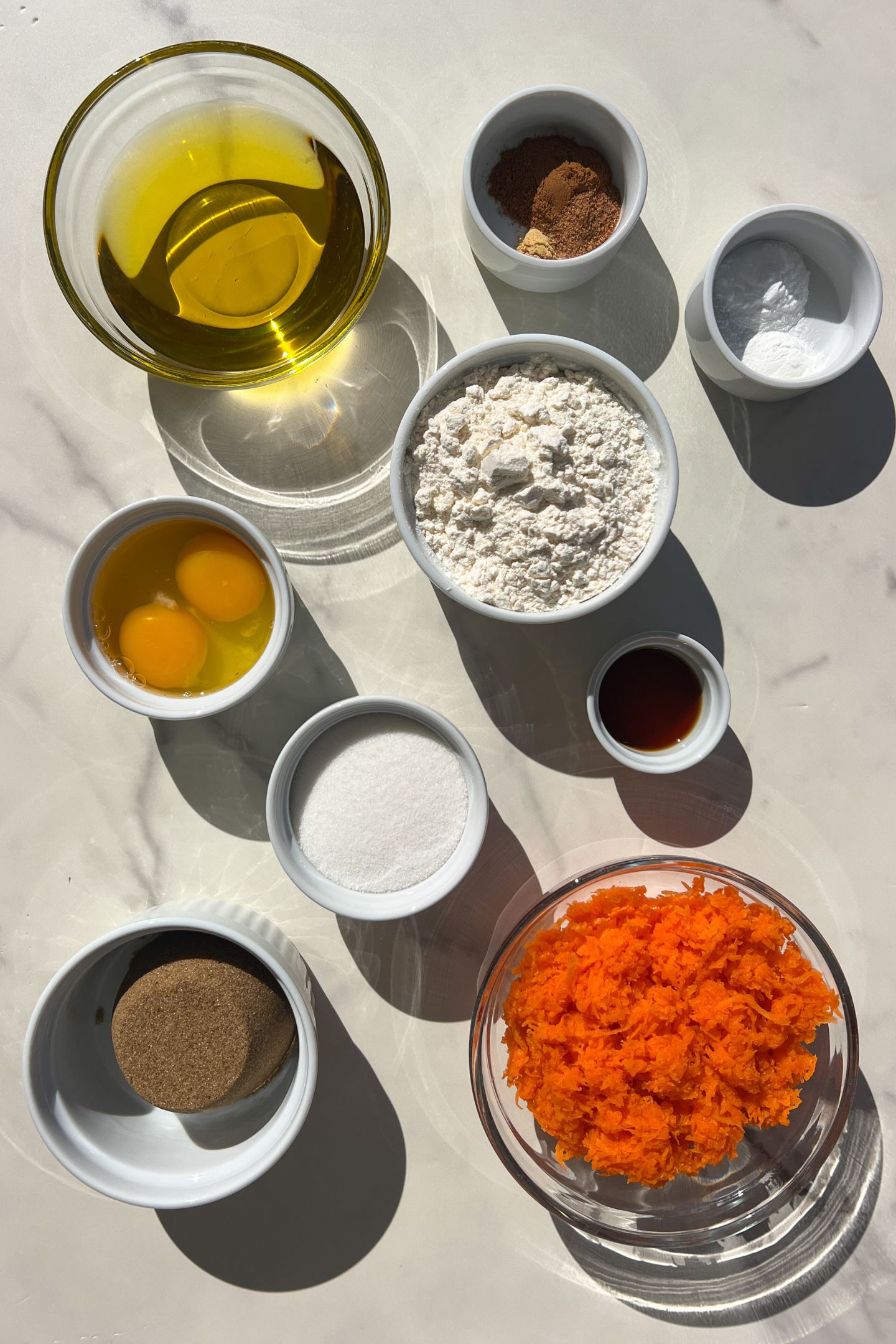 Ingredients measured out in bowls to make mini carrot cake recipe.
