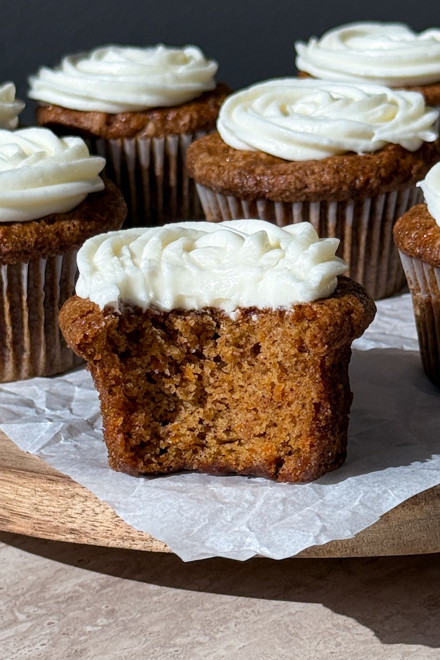 Gluten free carrot cake cupcake with a bite taken out of it.